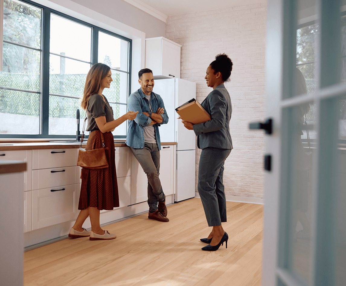 Couple touring modern kitchen with agent